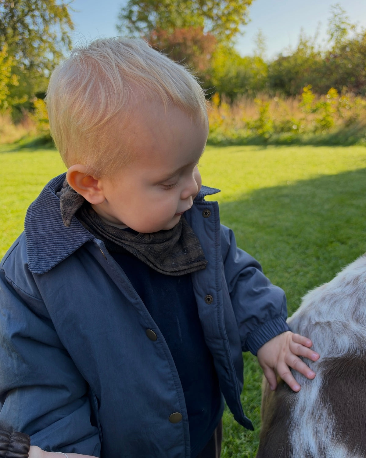 Boy outdoors in a jacket and Coffee Bean scarf