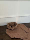 Brown long-sleeved pointelle bodysuit lying on a wooden table