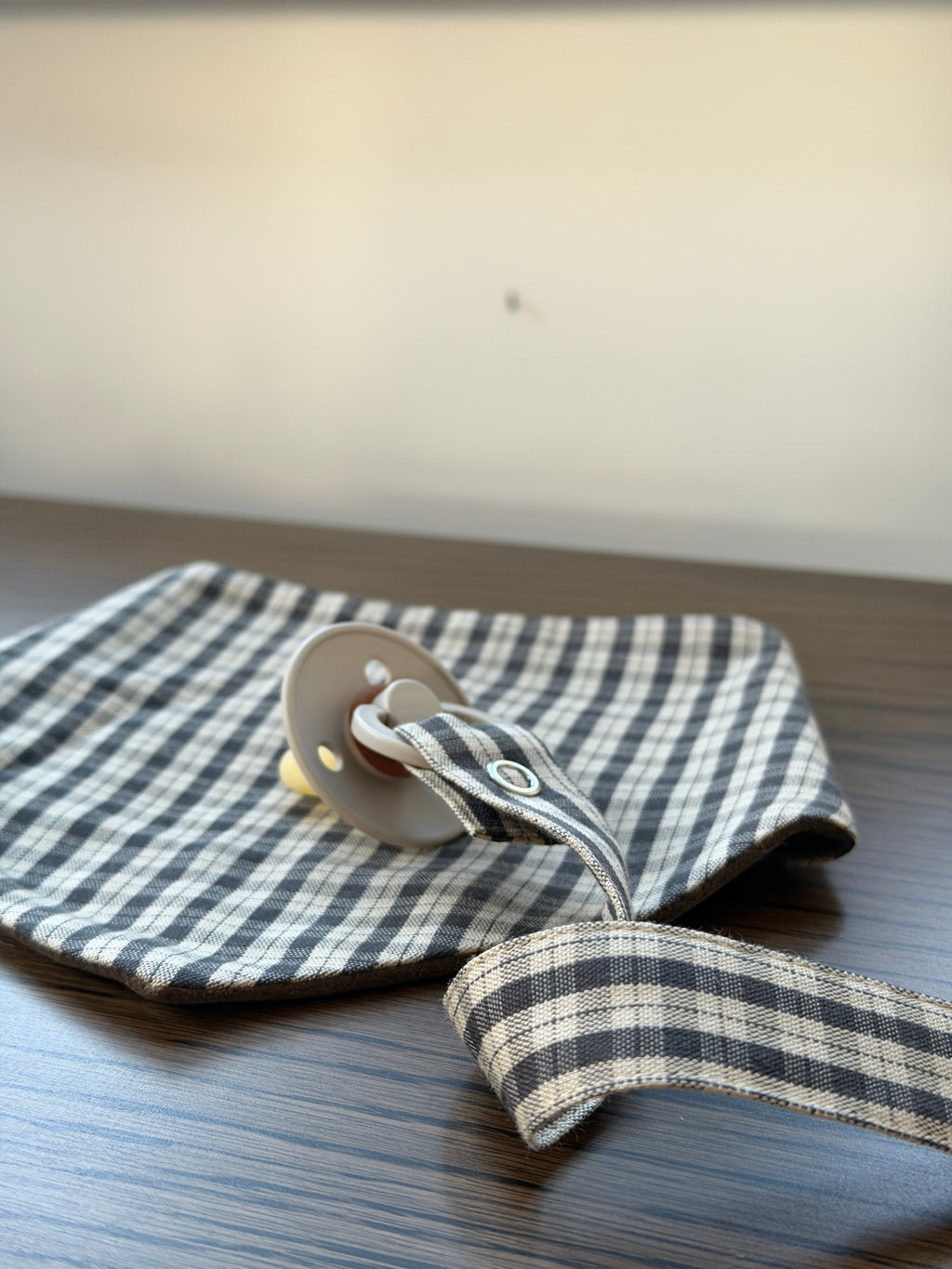 Mocca bib with dummy clip on a wooden table