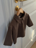 Brown waffle-knit polo shirt on a hanger on a door