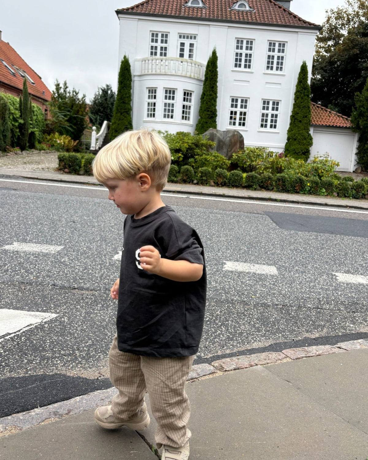 Cappuccino trousers in light beige check cotton – boy on the pavement