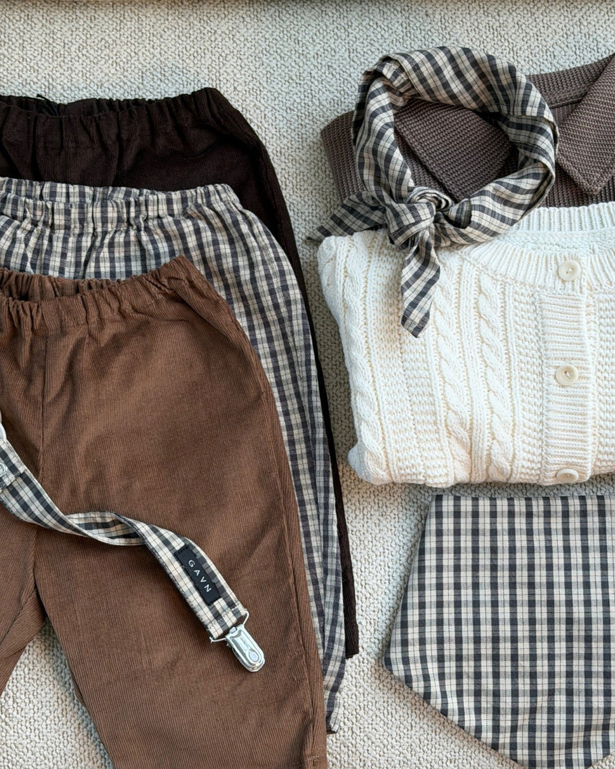 Flat lay with trousers, scarf and Mocca bib