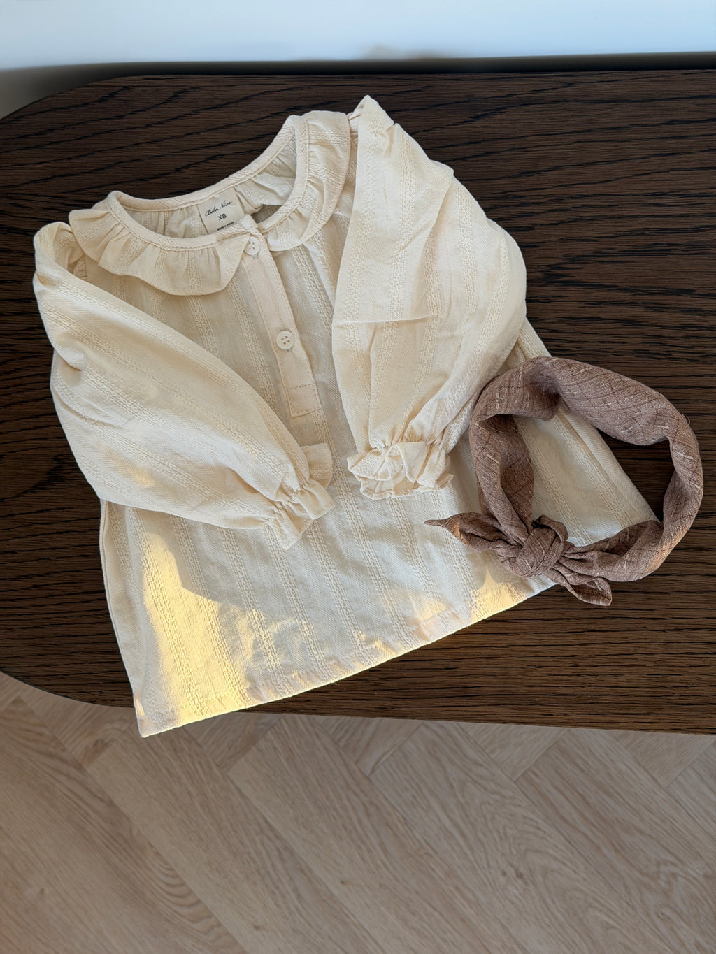 Creme skjortebluse med flæsekrave liggende med tørklæde