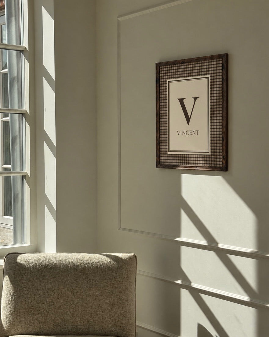 Cortado navneplakat med initial og navn hængende på en lys væg