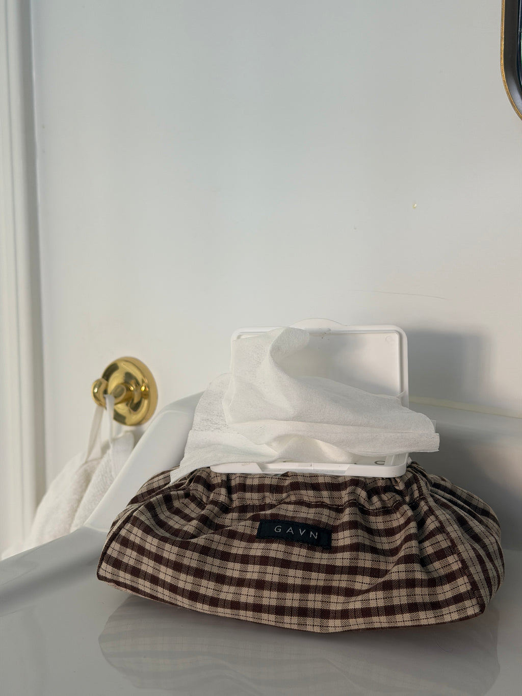 Cortado wet wipes case in brown and beige check cotton on a white worktop in the bathroom