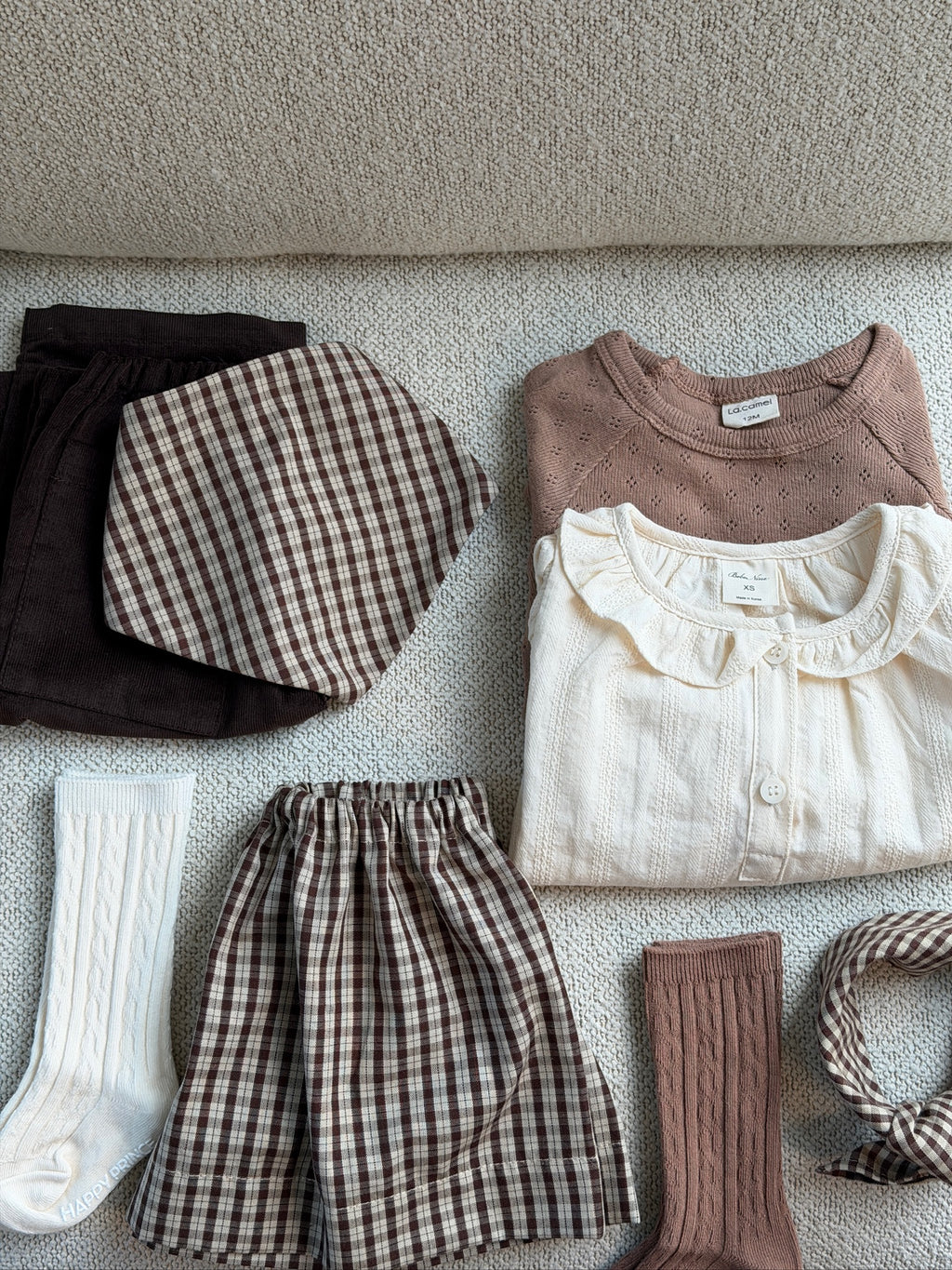 Creme skjortebluse med flæsekrave – flatlay med bluser, nederdel og strømper