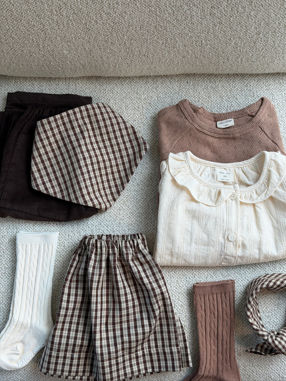 Creme skjortebluse med flæsekrave – flatlay med bluser, nederdel og strømper
