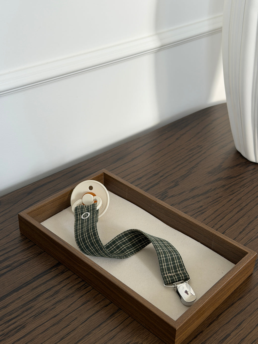 Pine dummy clip in green check cotton with a dummy in a wooden tray